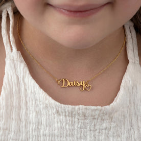 Child wearing a gold 'Daisy' personalised name necklace