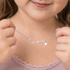 Young girl holding silver 'Emma' necklace with star charm - Ruby font